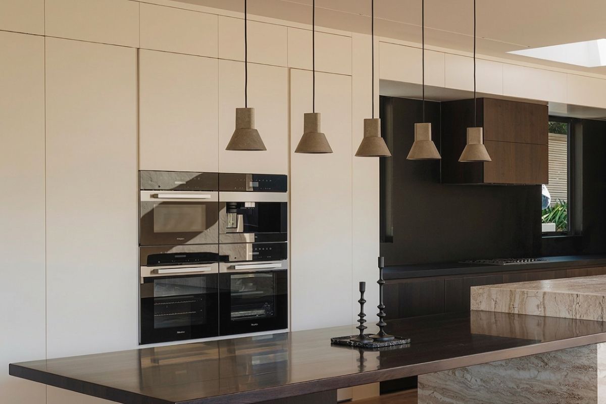 Cocina a medida en roble oscuro con mesada de granito negro e isla con anafe
